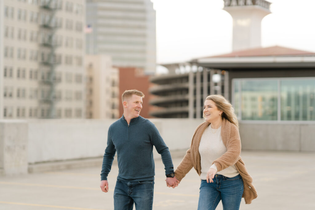 An engaged couple posing and smiling for photographs in various locations around Spokane. The photos showcase the city's diverse scenery, including parks, bridges, historic buildings, and urban streets. The couple's love-filled moments are captured against a backdrop of Spokane's charming and scenic locations